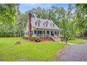 View of home with metal roof and welcoming front porch, situated in a lush, green lawn at 196 Dogwood Ridge Rd, Summerville, SC 29485