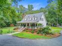 Aerial view of the home, showcasing its metal roof, porch, landscaping, and serene wooded surroundings at 196 Dogwood Ridge Rd, Summerville, SC 29485