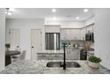 Modern kitchen with stainless steel appliances, granite countertops, and sleek gray cabinetry at 207 Thomaston Ave, Summerville, SC 29485