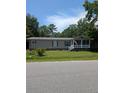 Attractive one-story home with a charming front porch, set on a green lawn with mature trees at 215 Hines Dr, Bonneau, SC 29431
