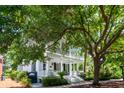 Stately two-story home with a charming front porch and balcony shaded by mature trees at 220 Ponsbury Rd, Mount Pleasant, SC 29464