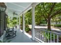 Relaxing front porch with rocking chairs and a view of the picturesque, tree-lined neighborhood at 220 Ponsbury Rd, Mount Pleasant, SC 29464