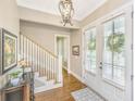 Elegant foyer features hardwood floors, staircase, chandelier, and double entry doors for bright natural light at 2800 River Vista Way, Mount Pleasant, SC 29466