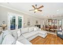 Open concept living room features a large sectional sofa, hardwood floors, and seamless access to kitchen and dining area at 2800 River Vista Way, Mount Pleasant, SC 29466