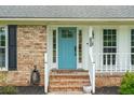 Welcoming home entrance featuring a vibrant blue door, brick steps, and white trim at 2942 Foxhall Rd, Charleston, SC 29414