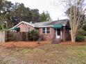 Brick home showcasing awnings, well-maintained front yard, and classic architectural details at 3034 Maybank Hwy, Johns Island, SC 29455