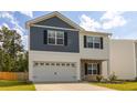 Two-story home featuring blue and white siding, a stone facade, a two-car garage, and a well-kept lawn at 304 Torslanda Ln, Summerville, SC 29486