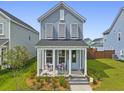 Inviting two-story home with a charming front porch, seating area, lush lawn, and well-maintained landscaping at 330 Ripple Park Dr, Summerville, SC 29486