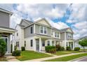 Attractive exterior view featuring well-maintained townhomes with manicured lawns and beautiful blue sky at 3927 Four Poles Park Dr, North Charleston, SC 29405