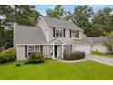 Traditional home featuring lush green lawn, mature trees, and tidy landscaping at 633 Alwyn Blvd, Summerville, SC 29485