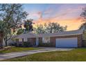 Charming brick home with manicured lawn and beautiful trees under a colorful sky at 689 Port Cir, Charleston, SC 29412