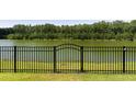 Wrought iron fence surrounding the backyard with mature trees and access to the lake at 7011 Pumpkinseed Dr, Johns Island, SC 29455