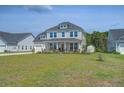 Charming two-story home boasts a two-car garage, large front yard and inviting front porch at 7035 Pumpkinseed Dr, Johns Island, SC 29455