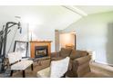 Comfortable living room with a cozy fireplace, brown sofa, and white and patterned chairs at 7621 Oldridge Rd, North Charleston, SC 29418