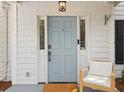 Inviting front door with decorative sidelights and charming chair, showcasing welcoming entrance at 800 Heyward Cove Pl, Charleston, SC 29412