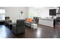 Open-concept living area featuring sleek hardwood floors and ample natural light at 8127 Saveur Ln, Charleston, SC 29406