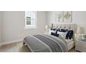 Comfortable bedroom with a neutral color palette, soft carpet, a tufted headboard, and natural light from a window at 89 French Garden Cir, Summerville, SC 29486