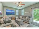 Inviting living room with a comfortable grey sofa, ceiling fan, and a large TV for entertainment at 9101 Parlor Dr, Ladson, SC 29456