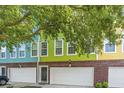 The townhome has a white garage door, red brick accents and is painted light green at 9305 Sweetbay Ct, Ladson, SC 29456