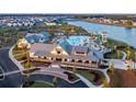 Beautiful aerial view of a community clubhouse with a resort-style pool, lake and neighborhood in the background at 99 French Garden Cir, Summerville, SC 29486