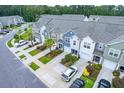 An aerial view displays a community of well-maintained townhomes in a lush, green setting at 108 Rosefield Ct, Summerville, SC 29485