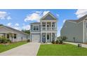 A charming two-story home featuring a covered porch and well-manicured lawn at 116 Midmills Ln, Summerville, SC 29486