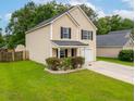 A charming two-story home featuring a well-kept lawn, and an attached garage at 117 Ducane St, Summerville, SC 29483