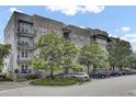 Beautiful exterior of a multi-story condo building with balconies and mature trees at 125 Pier View St # 209, Charleston, SC 29492