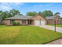 Beautiful brick home featuring a lush green lawn and a spacious two-car garage at 1304 Pinyon Pine Dr, Ladson, SC 29456