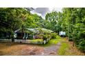 Quaint home featuring a white picket fence, screened porch and mature, lush landscaping at 1384 Tibwin Rd, McClellanville, SC 29458