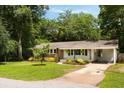 Inviting single-story home featuring brick accents, a carport, and lush landscaping at 1417 Downing St, Charleston, SC 29407