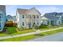 Attractive two-story home with dual porches and verdant landscaping on a sunny day at 176 Midtown Ave, Summerville, SC 29486