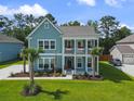 Inviting two-story home showcasing dual balconies, manicured lawn and tropical trees at 1973 Parish House Cir, Johns Island, SC 29455