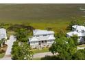 Breathtaking aerial view of a beautiful home, surrounded by trees and the bay at 2618 Raven Dr, Sullivans Island, SC 29482
