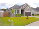 Charming single-Gathering home with a two-car garage, well-manicured lawn and neutral color scheme at 303 Citation Way, Moncks Corner, SC 29461