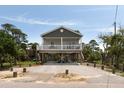 Well-maintained elevated beach house with a covered porch and outdoor parking at 31 W 9Th St, Folly Beach, SC 29439
