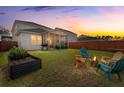 Inviting backyard with a fire pit, screened-in porch, and a well-maintained fence at 315 Black Birch Dr, Summerville, SC 29486