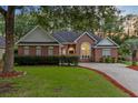 Beautiful brick home with manicured lawn and driveway, exuding classic elegance and curb appeal at 4209 Wildwood Lndg, Charleston, SC 29420