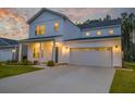 Charming two-story home with white siding, a welcoming front porch, a wide driveway and a two-car garage at 4374 Cotton Flat Rd, Summerville, SC 29485