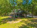 Aerial view of home with a sprawling lawn and mature trees, showcasing its well-maintained grounds and setting at 6385 Shilelagh Oaks Pkwy, Ravenel, SC 29470