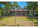 Charming two-story brick home featuring a wide covered porch, offering a welcoming and classic curb appeal at 6385 Shilelagh Oaks Pkwy, Ravenel, SC 29470