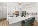 Bright, open kitchen featuring a quartz countertop island, stainless steel appliances, and pendant lighting at 703 Blueway Ave, Summerville, SC 29486