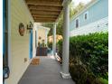 Covered porch with wood flooring and views of the well-kept yard and neighboring house at 907 High Nest Ln, Charleston, SC 29412