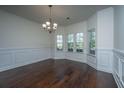 Elegant dining room showcasing hardwood floors, wainscoting, bay windows, and a chandelier at 9710 Table Mountain Ln, Ladson, SC 29456