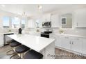 Modern kitchen featuring white cabinets, stainless steel appliances, and a large island with seating at 1009 Marsh Harrier Dr # Cc3-2-2P, Ravenel, SC 29470