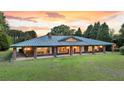 Stunning brick home with a green metal roof, porch columns, and large manicured front yard at 1085 Harts Bluff Rd, Wadmalaw Island, SC 29487