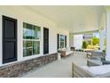Covered front porch showcases ample seating and stylish decor, perfect for relaxation and curb appeal at 114 Rust Rail Way, Summerville, SC 29485