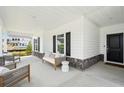 Inviting covered front porch featuring stone accents, outdoor seating, and a stylish welcome mat at 114 Rust Rail Way, Summerville, SC 29485