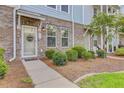 Attractive brick townhome featuring a welcoming front door and professionally landscaped yard at 136 Rowans Creek Dr, Charleston, SC 29492