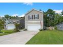 Two-story home with a two-car garage, a well-maintained lawn, and a concrete driveway in a residential area at 141 Lagoona Dr, Summerville, SC 29483